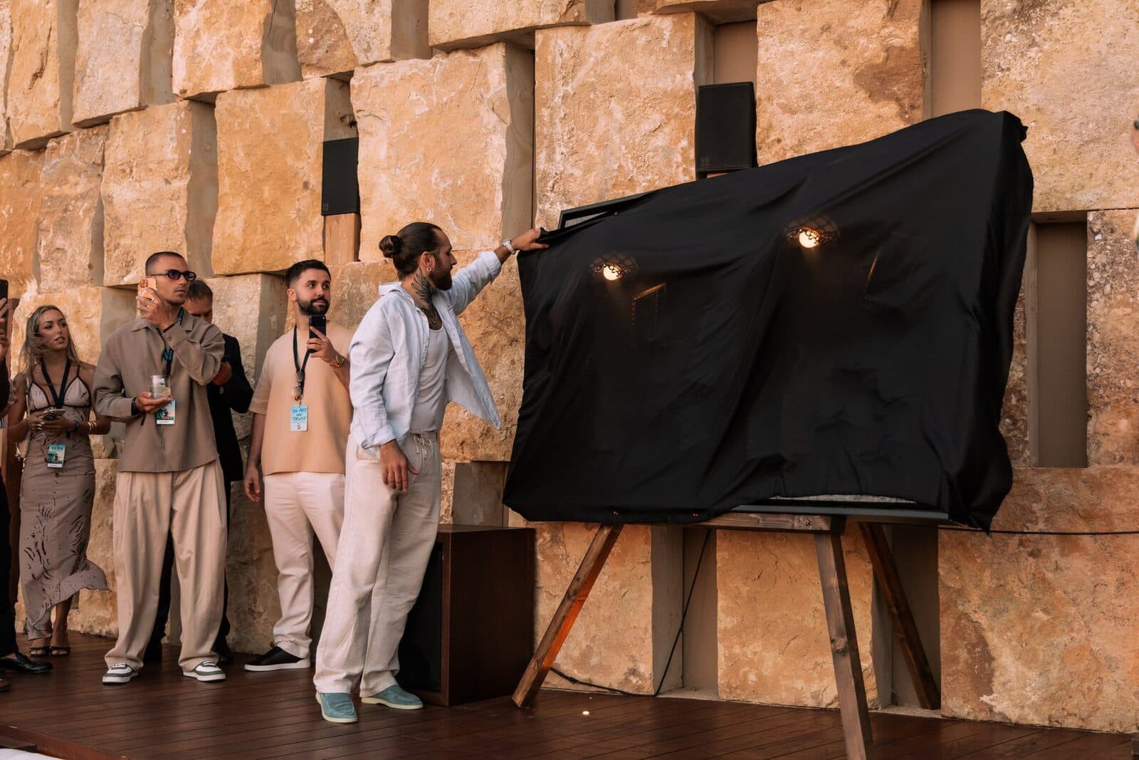 Unveiling of a covered work in front of guests at Zuma Mykonos